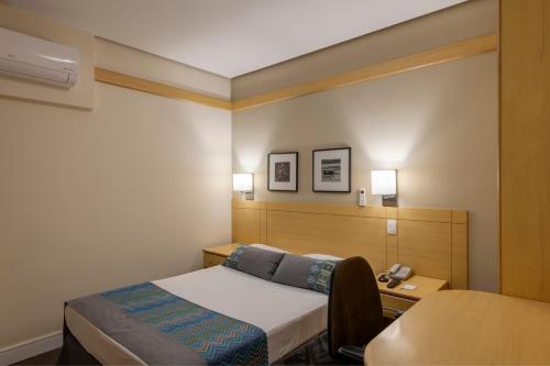 a hotel room with a bed and a telephone at Monreale Plus Guarulhos International Airport in Guarulhos
