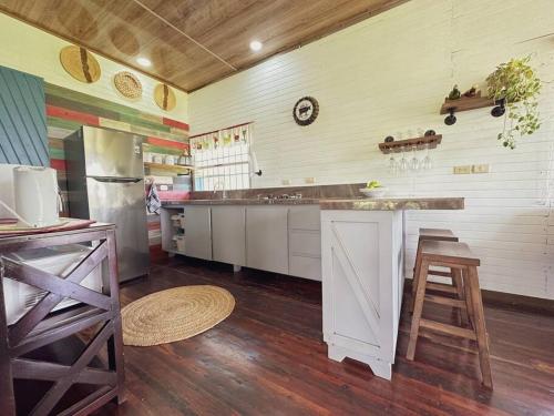cocina con armarios blancos y encimera en una habitación en Casa de Campo Riachuelo Verde, en Aguas Zarcas