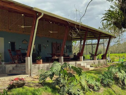 una casa con un pabellón en un campo en Casa de Campo Riachuelo Verde, en Aguas Zarcas