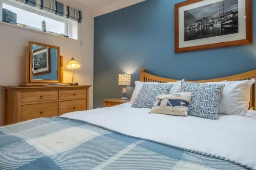 a bedroom with a bed with a blue wall at Hideaway House in Wells next the Sea