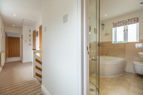 a bathroom with a tub and a toilet and a sink at Hideaway House in Wells next the Sea