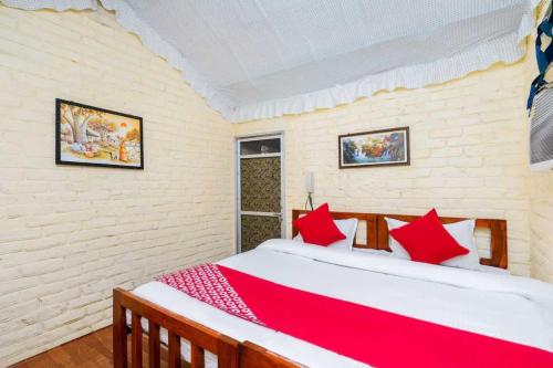een slaapkamer met een groot bed met rode kussens bij OYO Flagship RS Woods in Pushkar
