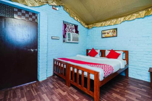 een slaapkamer met een houten bed met rode kussens bij OYO Flagship RS Woods in Pushkar