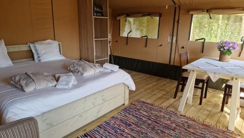 ein Schlafzimmer mit einem Bett und einem Tisch in einem Zimmer in der Unterkunft Happiness in Brügge