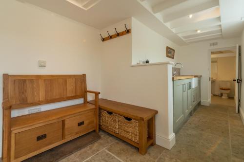 a kitchen with a wooden cabinet and a sink at Old Posting in Brancaster