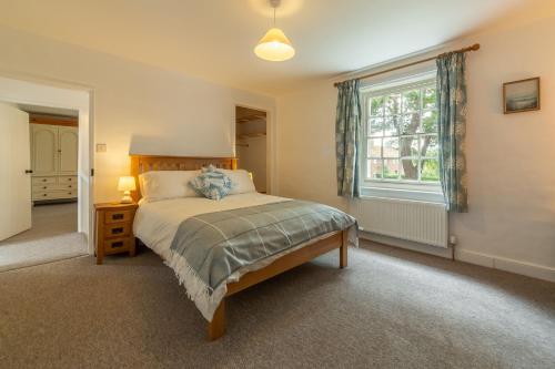 a bedroom with a bed and a window at Old Posting in Brancaster
