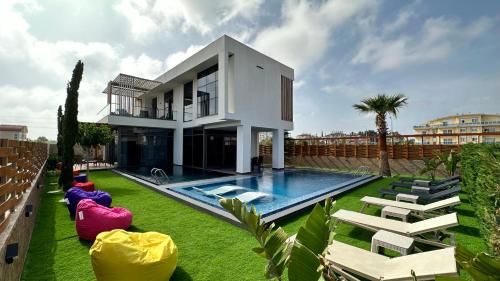 a house with a swimming pool and some chairs at DrVilla°Suits in Belek