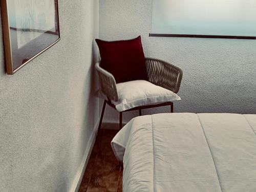 1 dormitorio con silla y 1 cama en una habitación en Puerto de Mazarron 300m plage Bahia, en Puerto de Mazarrón