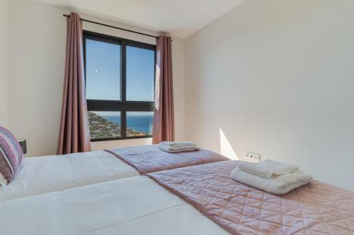a bedroom with a bed with a large window at Banana Tree in Câmara de Lobos