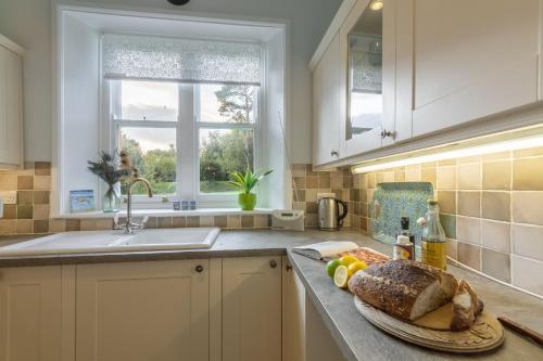 una cocina con una barra de pan en Coachmans Cottage, en New Hunstanton