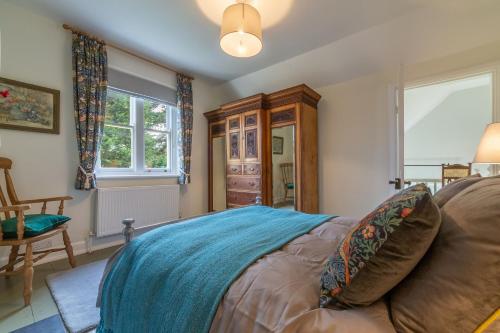 1 dormitorio con 1 cama, 1 silla y 1 ventana en Coachmans Cottage, en New Hunstanton