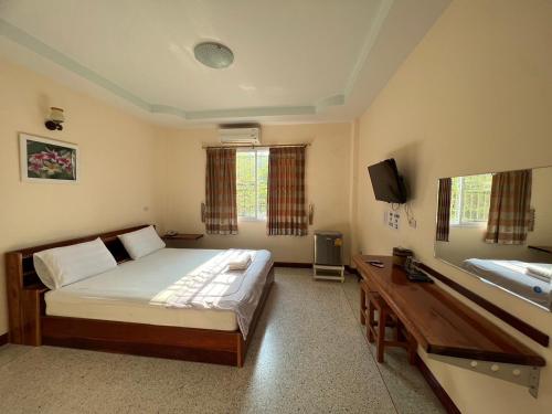 Khong Chiam 2 Hotel في خونغ شيام: غرفة نوم بسرير ومكتب وتلفزيون