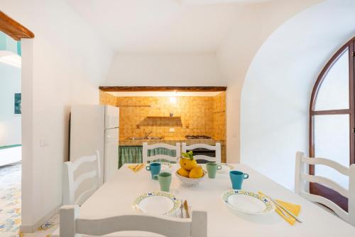 a kitchen with a white table and a white refrigerator at Torre Turbolo Apartments in Massa Lubrense