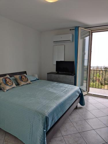 a bedroom with a bed and a balcony with a television at Casa Josè Suite Mare in Palermo