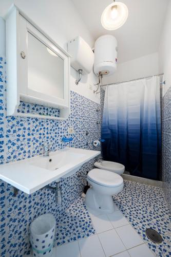 a blue and white bathroom with a toilet and a sink at Torre Turbolo Apartments in Massa Lubrense