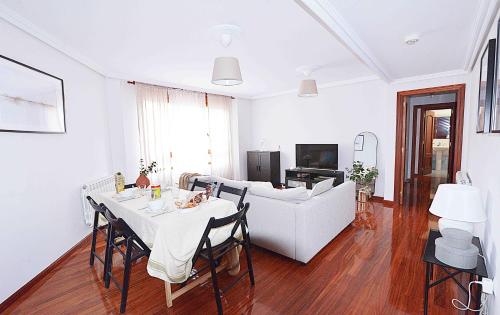 sala de estar con mesa y sofá en El Apartamento de Adina, en Santiurde de Toranzo