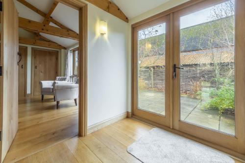 a pivot door in a living room with sliding glass doors at Princes Barn in Neatishead