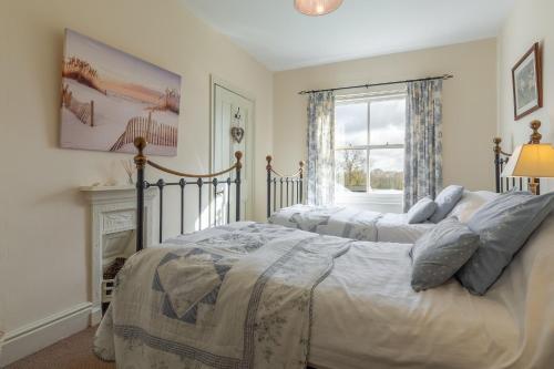 Ludham的住宿－Ludham Hall Cottage，一间卧室设有两张床和窗户。