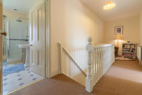 Ludham的住宿－Ludham Hall Cottage，一条有白色楼梯和楼梯的走廊