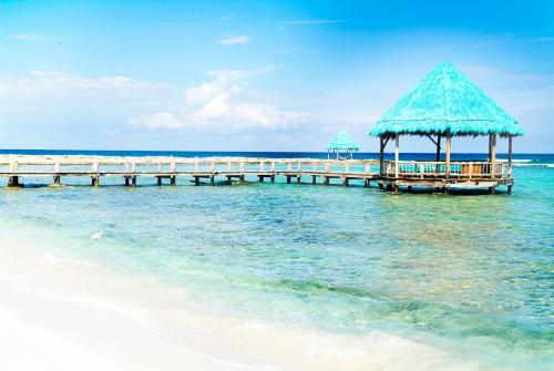 a pier with a pavilion in the water on the beach at Grand Oasis Tulum Riviera - All Inclusive in Akumal