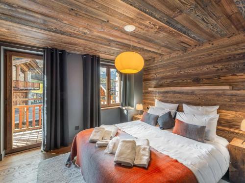 1 dormitorio con 1 cama grande y paredes de madera en Chalet Saint-Martin-de-Belleville, 8 pièces, 15 personnes - FR-1-570-38, en Saint-Martin-de-Belleville
