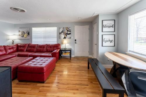 a living room with a red couch and a table at Hidden Gem of Arvada! in Arvada