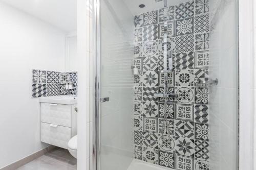 La salle de bains est pourvue d'une douche et d'un mur en carrelage. dans l'établissement La Mouette Tranquille, à Brest