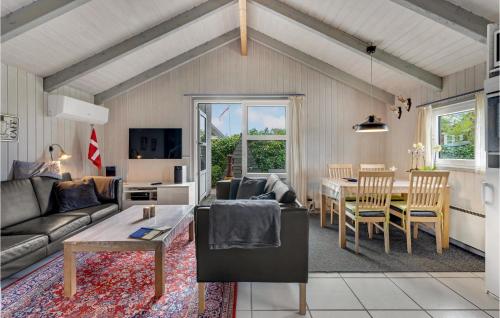 a living room with a couch and a table at Holiday Home Hemmet 37 in Falen