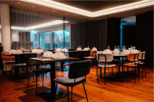 uma sala de jantar com mesas e cadeiras com guardanapos brancos em SOLLER Business Hotel - Munich Airport MUC em Hallbergmoos
