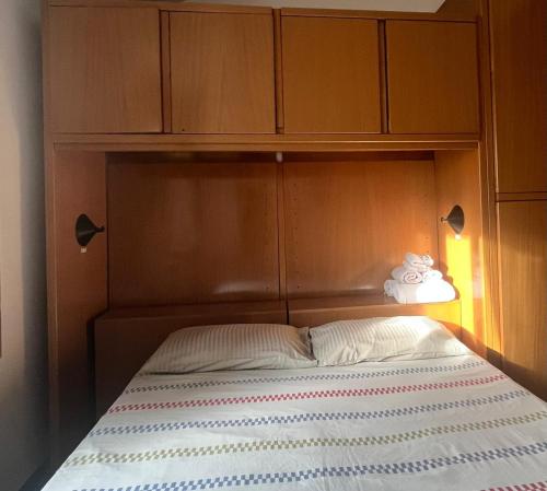 1 cama con cabecero de madera y armarios encima en Malvezzi 36, en Fano