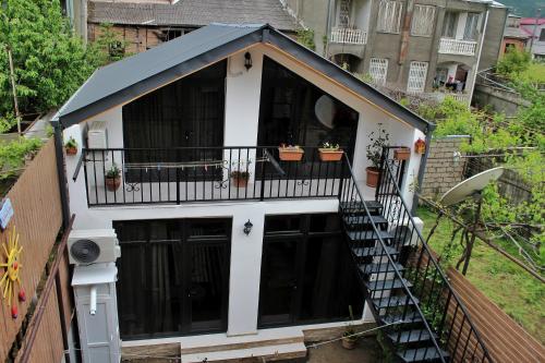 een klein huis met een balkon en een trap bij Nitsa Guest House in Gori