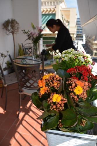 a woman is arranging flowers on a table at La Dimora in Catania