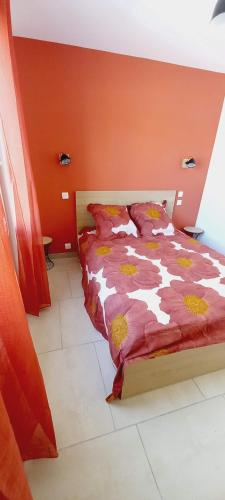 een bed in een slaapkamer met een oranje muur bij Villa neuve avec piscine chauffée dans le Lubéron in Villeneuve