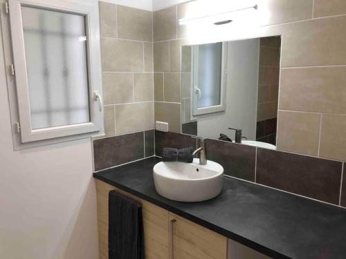 La salle de bains est pourvue d'un lavabo blanc et d'un miroir. dans l'établissement Villa neuve avec piscine chauffée dans le Lubéron, à Villeneuve