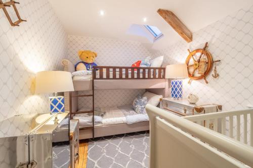 Habitación infantil con literas y osito de peluche en The Malthouse, en Dersingham