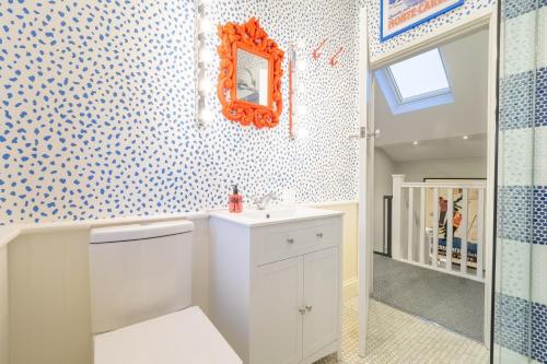 baño con lavabo y espejo en la pared en The Malthouse, en Dersingham