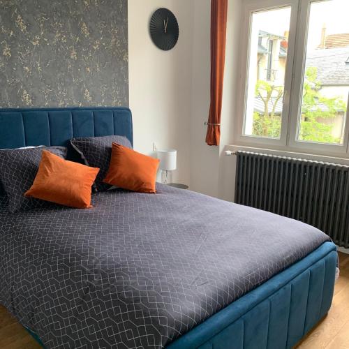 - un lit bleu avec des oreillers orange dans une chambre dans l'établissement La suite du Theatre, à Bourges