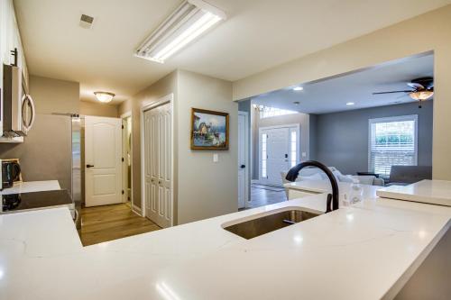 a kitchen with a sink and a living room at Charming Lewes Townhome with Sunroom 5 Mi to Beach! in Lewes