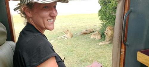 a woman sitting in a vehicle with a group of lions at Maasai homestay camping in Sekenani