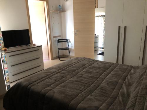 sypialnia z łóżkiem i komodą z telewizorem w obiekcie Mansarda mentana w mieście Vittoria