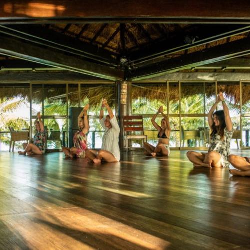 a group of women sitting in a yoga class at Serrambi Resort in Porto De Galinhas