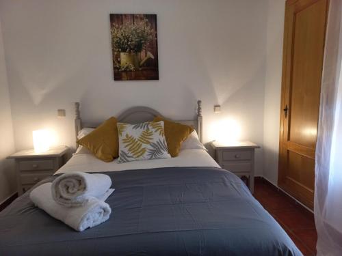 a bedroom with a bed with a towel on it at HOTEL LOS ARENALES DE JERTE in Jerte