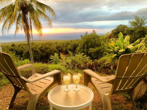 two chairs and a table with two glasses on it at Kona Bayview Inn in Captain Cook