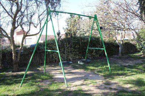 an empty green swing set in a yard at Hotel Un lugar en la Vecilla in Dueñas