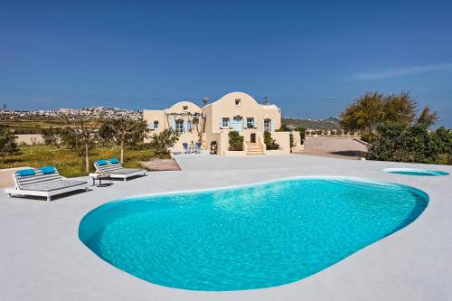 a large swimming pool in front of a house at Sienna Eco Resort in Fira