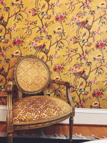 a chair in front of a wall with a floral wallpaper at Marianna Stoltz House in Spokane