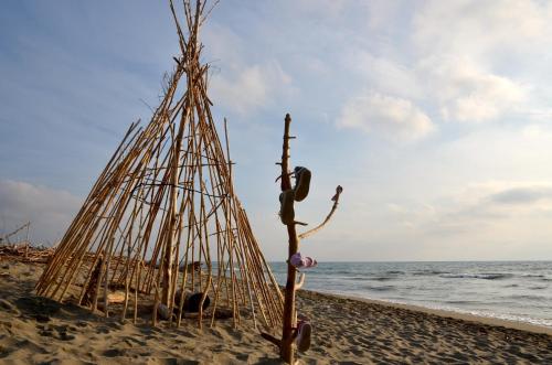 a stick hut on the beach next to the ocean at Petit Hotel in Lido di Camaiore