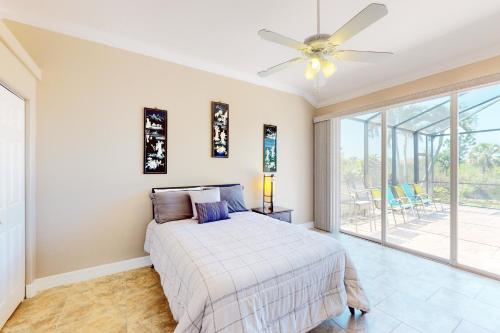 een slaapkamer met een bed en een plafondventilator bij Blazing Sunshine in Bonita Springs
