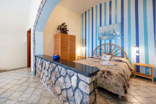 a bedroom with a bed and blue and white stripes at Torre Turbolo Apartments in Massa Lubrense