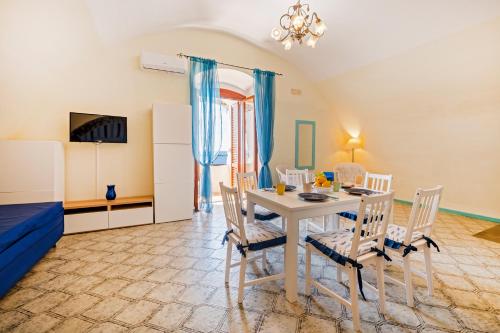 a dining room with a table and chairs at Torre Turbolo Apartments in Massa Lubrense